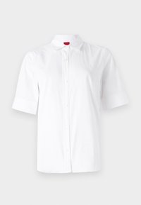 Chemise blanche à manches courtes avec boutons, col et logo brodé discret sur la poitrine, sur fond uni.
