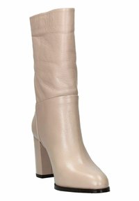 Stivale ankle in pelle beige con tacco a blocco alto, finitura liscia e design con risvolto nella parte superiore. Punta arrotondata e suola robusta.