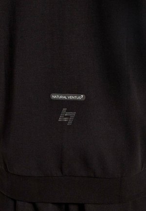 Primo piano di un tessuto nero con testo stampato "NATURAL VENTUS7" e un logo stilizzato "l7" in grigio nella parte inferiore.