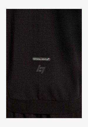 Primo piano di un tessuto nero con testo stampato "NATURAL VENTUS7" e un logo stilizzato "l7" in grigio nella parte inferiore.