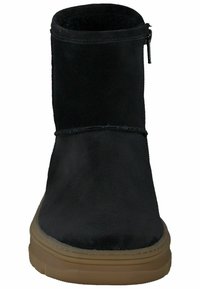 Botín de ante negro hasta el tobillo con punta redondeada, con cremallera lateral y suela de goma texturizada en tono marrón. Diseño minimalista sin patrones visibles.
