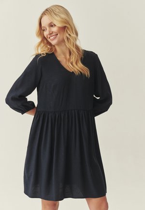 Čierne šaty dĺžky po kolená s dlhými naškrobenými rukávmi, výstrihom do V a zbieraným pásom; vyrobené z ľahkej látky s jemnou textúrou.