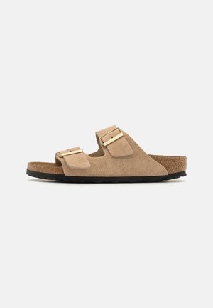 Sandalias de ante marrón con dos correas ajustables y hebillas metálicas, plantilla de corcho y suela de goma texturizada negra.