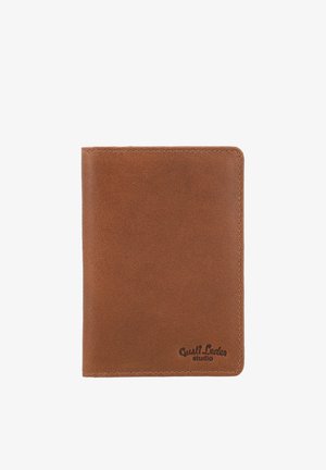 Bruine leren portemonnee met nette stiksels en "Gusti Leder studio" gegraveerd in de rechterbenedenhoek op een witte achtergrond.