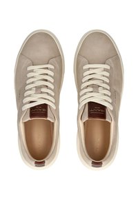 Beige semišové tenisky s krémovými tkaničkami, zaoblenou špičkou a světlou gumovou podrážkou. Na jazýčku se nachází hnědý kožený detail s embosovaným logem.