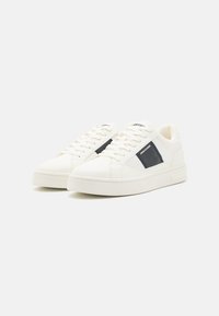 Weiße Ledersneaker mit navyblauen Akzenten, runder Zehenpartie und flacher Gummisohle. Ausgestattet mit klassischem Schnürverschluss und gesteppten Details.