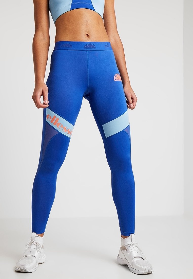 Niebieskie legginsy z jasnoniebieskimi akcentami, z logo na udzie i gładką, elastyczną fakturą. Zaprojektowane do aktywności fizycznej.