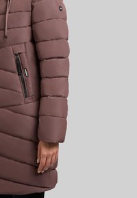 Polstret lang frakke i mauve med horisontal quiltet design, sidelomme med lynlås og snørelukning i hætten. Glat overflade og tætsiddende ærmer.