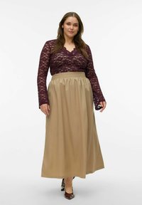 Lange mouwtop van kant in diep paars, gecombineerd met een beige maxi-rok met hoge taille, voorzien van een geplooide taille en een gladde textuur.