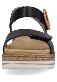 Sandale noire avec deux larges sangles, semelle intérieure beige et semelle texturée. Présente un accent tissé sur le côté et un design minimaliste.
