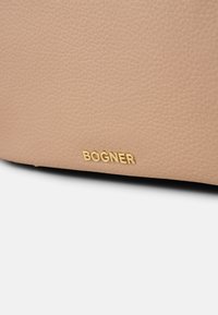 Bežna usnjena torba z teksturirano površino in zlatim logotipom "BOGNER" na dnu.