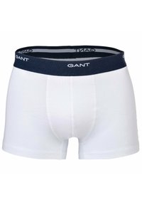 Boxer di cotone bianchi, con cinturino elastico blu scuro con logo "GANT" bianco. Texture liscia e design aderente.