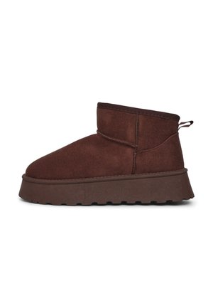 Bottines marron en daim avec une épaisse semelle plateforme et un bout arrondi. Présentent une petite languette au talon et des coutures décoratives.