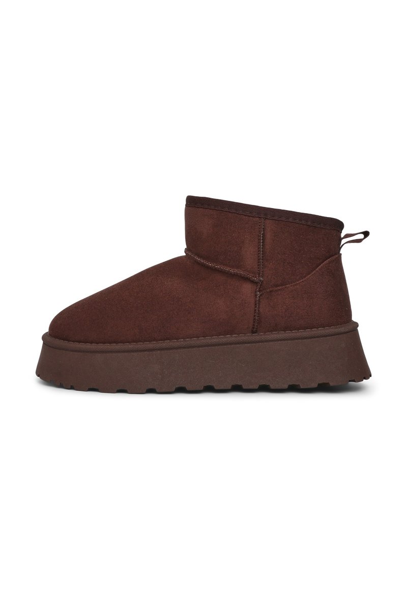 Bottines marron en daim avec une épaisse semelle plateforme et un bout arrondi. Présentent une petite languette au talon et des coutures décoratives.