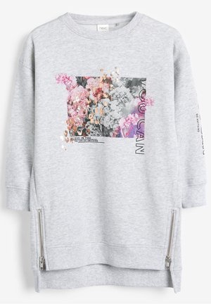 Sudadera de manga larga en gris claro con gráfico floral, texto en foil dorado que dice "CREÉ EN TI PUEDES HACER CUALQUIER COSA", cremalleras laterales y puños y dobladillo acanalados.