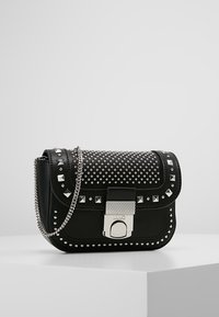 Svart läder crossbody-väska med silverdetaljer i form av både kvadrater och cirklar, silverkedjeaxelrem och strukturerat silverlås.
