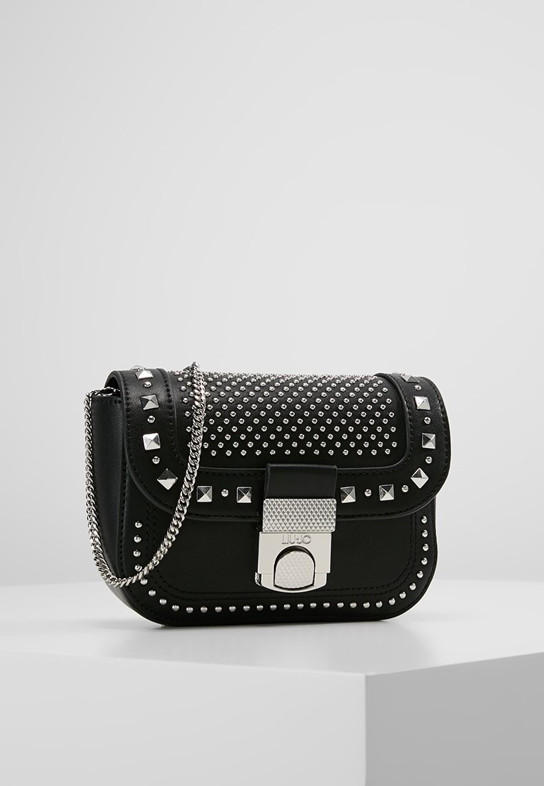 Svart läder crossbody-väska med silverdetaljer i form av både kvadrater och cirklar, silverkedjeaxelrem och strukturerat silverlås.