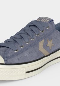 Μπλε σουέντ Converse sneaker χαμηλού προφίλ με μπεζ αστέρι και λογότυπο Chevron, λευκή καουτσούκ σόλα και κορδόνια στο ίδιο μπλε χρώμα.