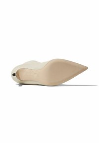 Zapato de tacón beige con puntera afilada, parte superior de cuero suave y una suela de color claro con detalles de marca mínimos.