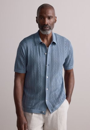 Short-sleeve sweater in soft blue knit with diamond patterns and ribbed details; features a button-down front and a straight hem.