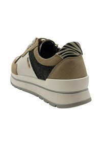 Zapatillas de deporte en beige y negro, con materiales de ante y textil, un respaldo con estampado de cebra, suela blanca y acentos texturizados.