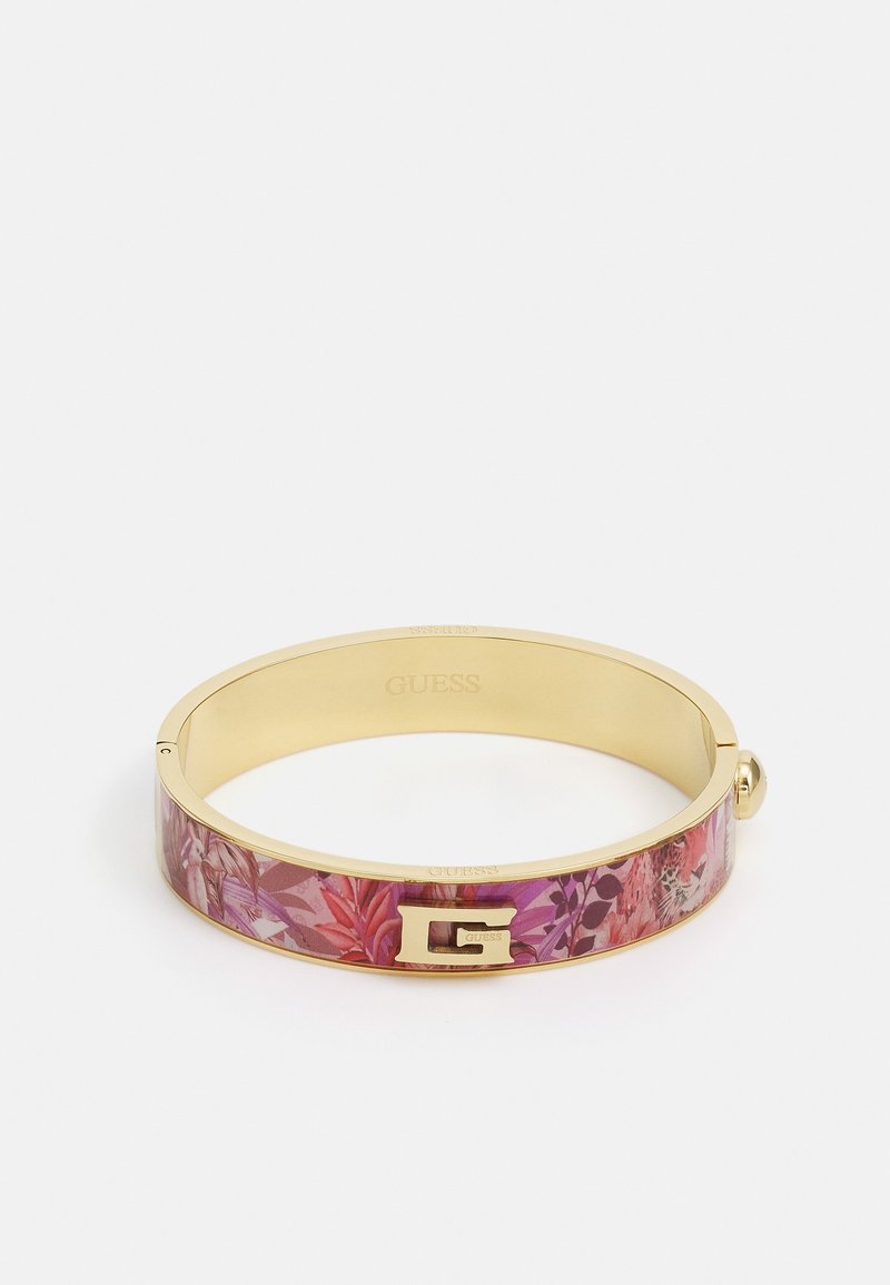 Bracelet jonc couleur or avec motif floral rose et un emblème "G" doré sur le devant, marqué "GUESS" à l'intérieur.
