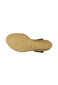 Semelle de chaussure en daim tan avec une surface texturée, bout arrondi et coutures détaillées le long du bord. Caractérisée par une semelle extérieure en caoutchouc naturel.