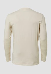 Lange mouwen crèmekleurig T-shirt van zacht materiaal, met een ronde halslijn en een eenvoudig ontwerp zonder patronen of accenten.