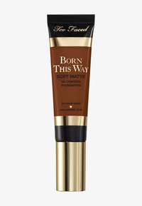 Tube marron du fond de teint mat et contrôle de l'huile Born This Way de Too Faced, avec des accents dorés et noirs, doté d'un distributeur à pompe et d'un design élégant.