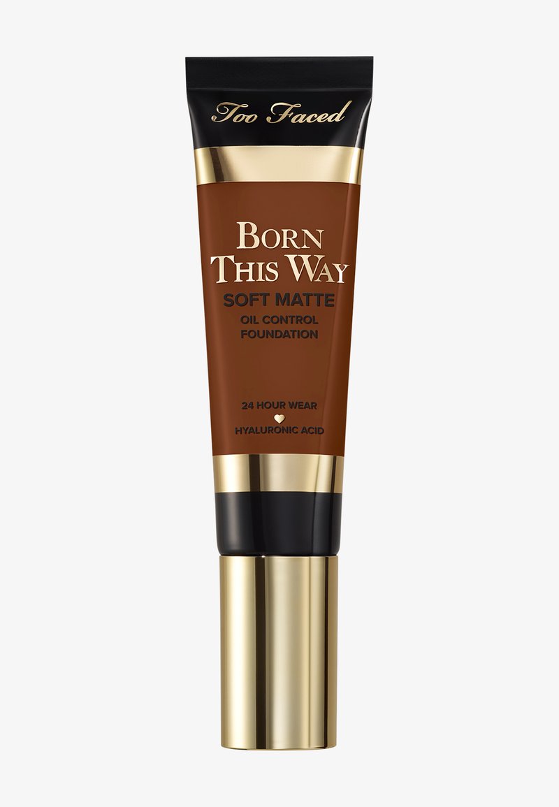 Tube marron du fond de teint mat et contrôle de l'huile Born This Way de Too Faced, avec des accents dorés et noirs, doté d'un distributeur à pompe et d'un design élégant.