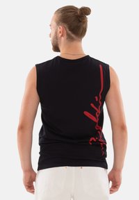 Schwarzes ärmelloses Shirt mit taillierter Passform, ausgestattet mit einem auffälligen roten Logo auf der linken Seite und einer glatten Baumwolltextur.