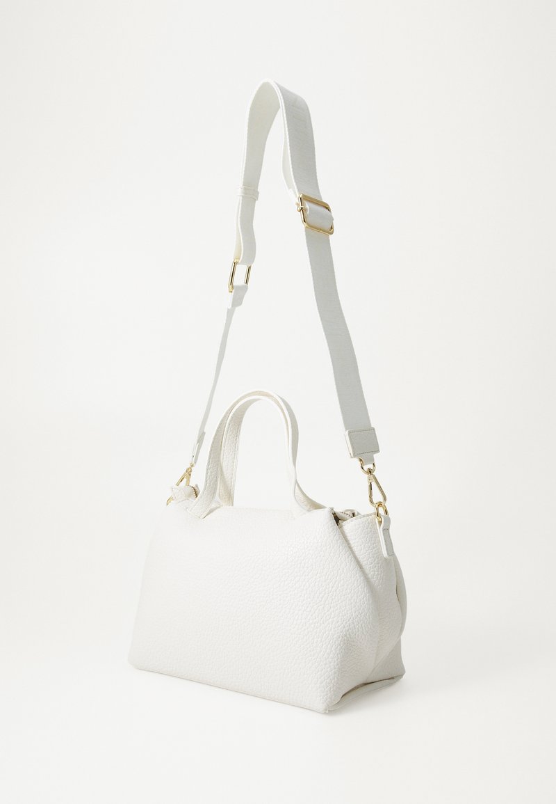 Bolso de mano de cuero blanco con textura granulada, que cuenta con dos asas superiores y una correa ajustable y desmontable con acentos de hardware dorado.