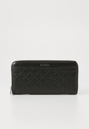 Black zippered wallet with quilted design featuring embossed logos. Smooth leather finish, rectangular shape, and silver-tone hardware detail.