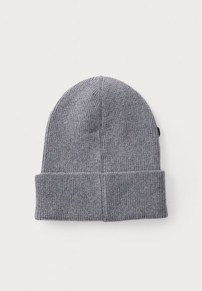 Bonnet en tricot gris avec une texture côtelée et un revers, présentant une petite étiquette de logo noire sur le côté.