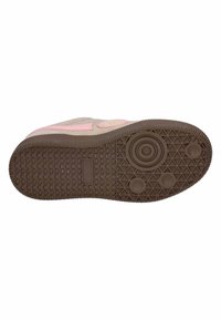 Tan rubber shoe sole with pink accents, patterned grip, circular and rectangular detailing, and textured ridges for improved traction.