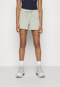 Shorts en coton gris avec une taille élastique et un cordon de serrage. Présente le logo brodé "GAP" à l'avant. Assortis avec des baskets grises et crème.