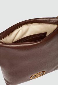 Borsa a tracolla in pelle marrone con superficie testurizzata, caratterizzata da una cerniera dorata e una tasca interna con una fodera beige chiaro.