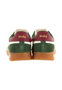 Zapatillas deportivas verdes y blancas con una suela de goma marrón, textura de ante y acentos en color granate. Logotipo de "Gola" mostrado en los talones.