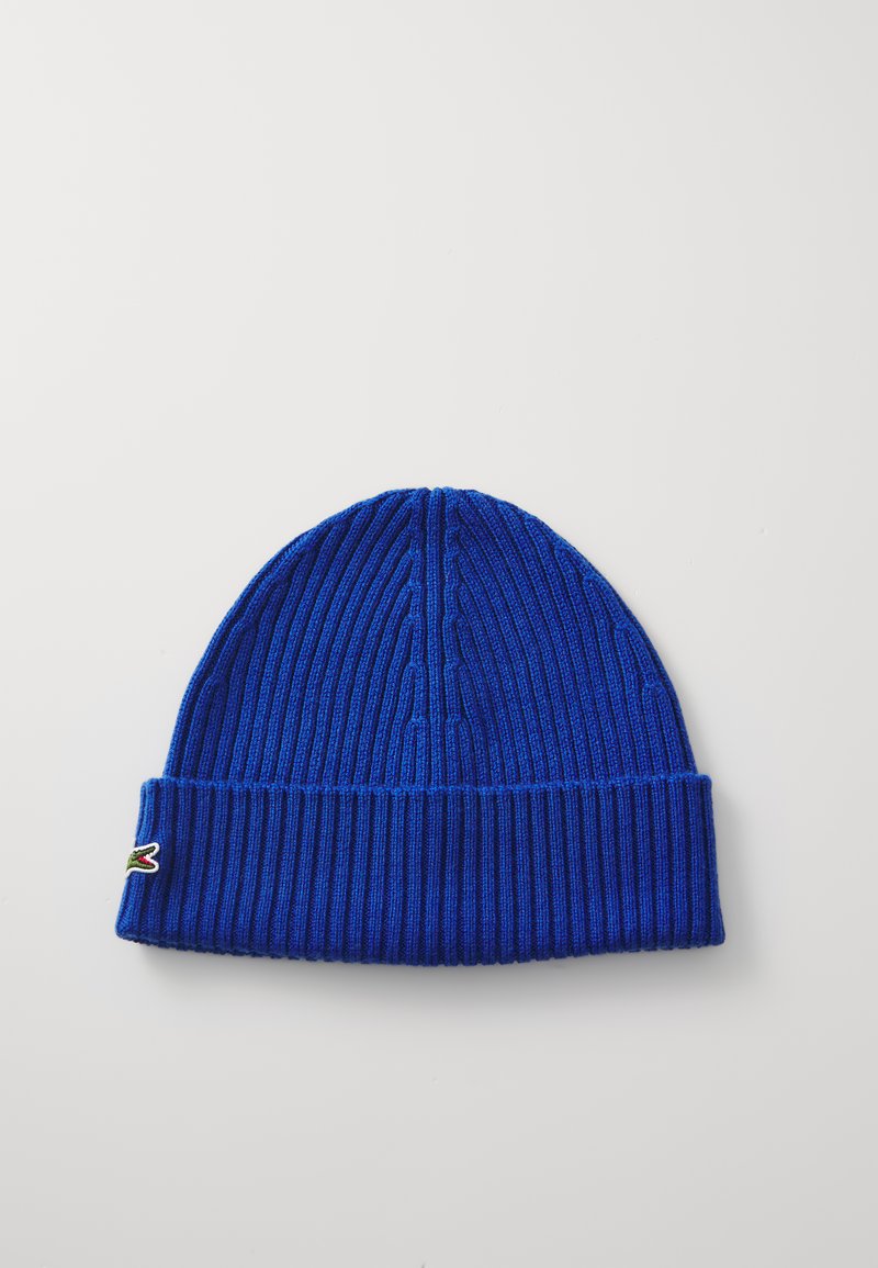 Blauer Strickbeanie mit vertikaler Rippstruktur. Verfügt über einen umgeschlagenen Bund und ein kleines Logo-Detail an der Seite. Sanfter und dehnbarer Stoff.