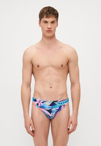 Boxeri de înot pentru bărbați cu un model colorat de frunze tropicale în nuanțe de roz, albastru și verde, pe un fundal întunecat. Material neted.