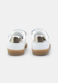 Weiße Sneaker mit metallischen goldenen Akzenten, verstellbaren Klettverschlussriemen und einer strukturierten Gummisohle für Traktion und Haltbarkeit.