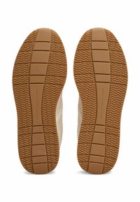 Soli delle scarpe con una texture ondulata e una presa con fantasia in gomma marrone. Fianchi in tessuto chiaro con righe orizzontali.