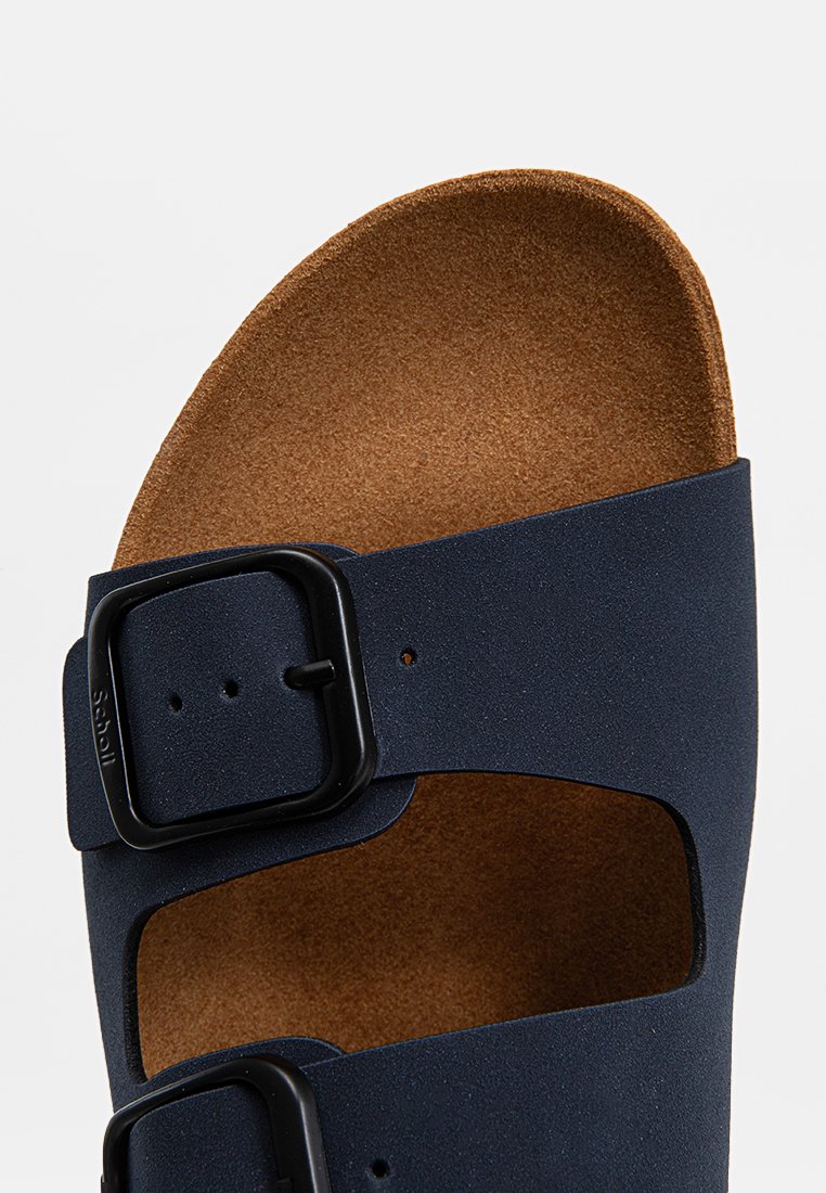 Sandale en synthétique bleu avec deux boucles noires ajustables, semelle en liège et design ouvert au niveau des orteils avec texture.