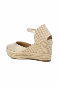 Zapato de cuña de esparto de color beige con parte superior de tela texturizada, media suela de yute trenzado y un acento de tela a cuadros en el talón.