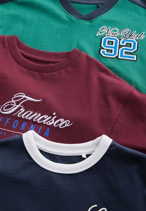 Tres sudaderas en colores variados: verde (con cuello azul marino), burdeos (con detalles blancos) y azul marino (con cuello blanco), con texto bordado.