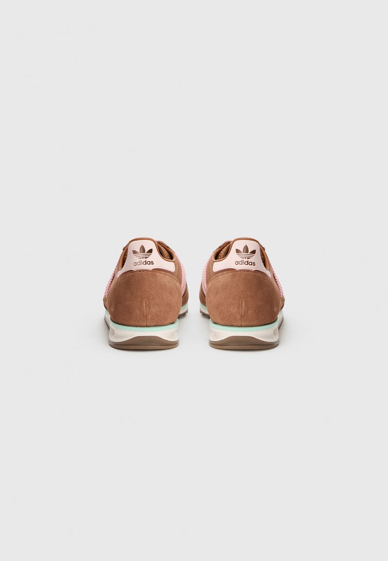 Pair of brown and pink Adidas sneakers, viewed from the back on a plain white background.