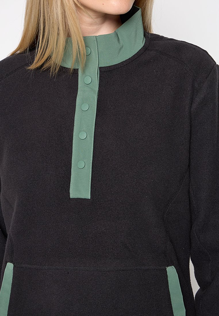 Zwarte fleece trui met groene kraag, voorzien van een knoopsluiting en zijzakken. Zachte textuur, casual ontwerp.