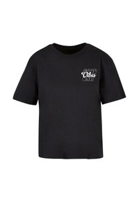 T-shirt noir à manches courtes en coton. Présente un design de texte blanc indiquant "QUE DES BONNES VIBRATIONS" sur le côté gauche du devant. Coupe droite.