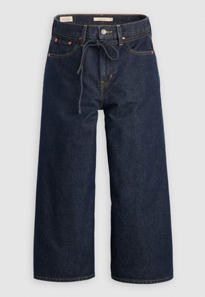 Jeans de mezclilla de pierna ancha en azul oscuro con cintura ajustable por cordón, bolsillos frontales y detalles de costura en naranja contrastante.