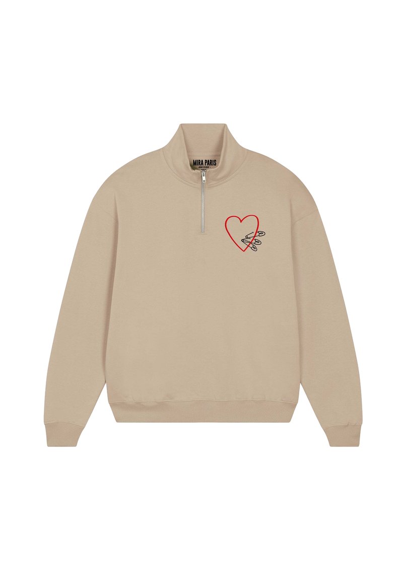 Felpa beige con collo a mezza zip. Presenta una grafica di un cuore rosso e schizzi di spille di sicurezza sul petto sinistro. Tessuto dalla consistenza morbida.